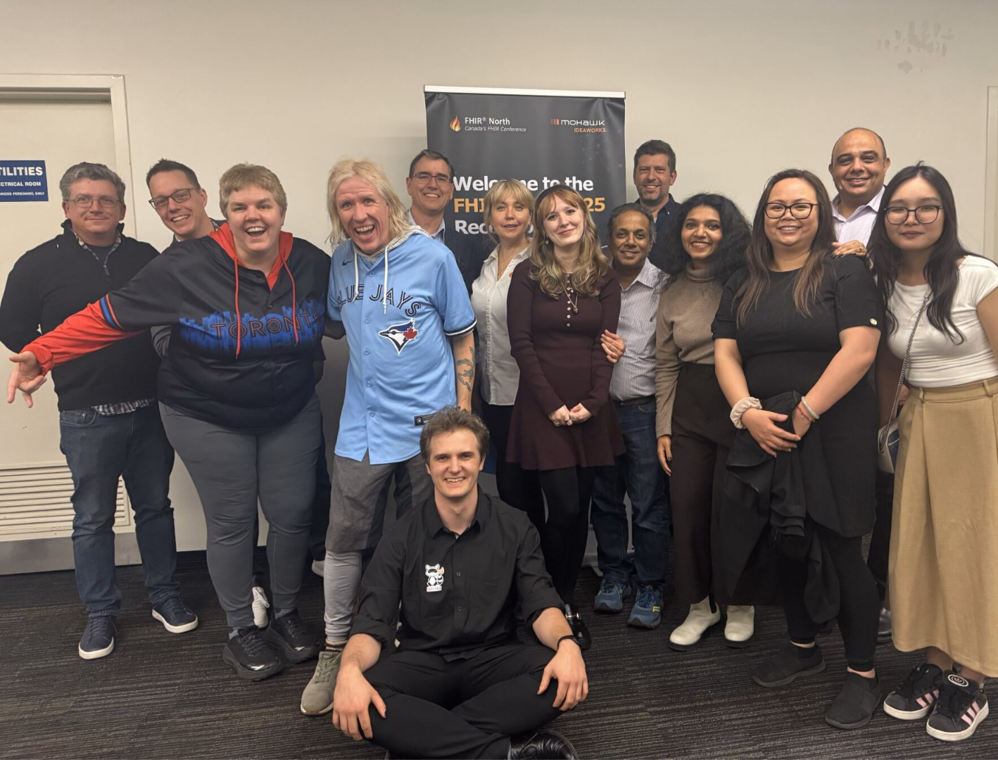 FHIR North 2025 reception — group photo with conference banner
